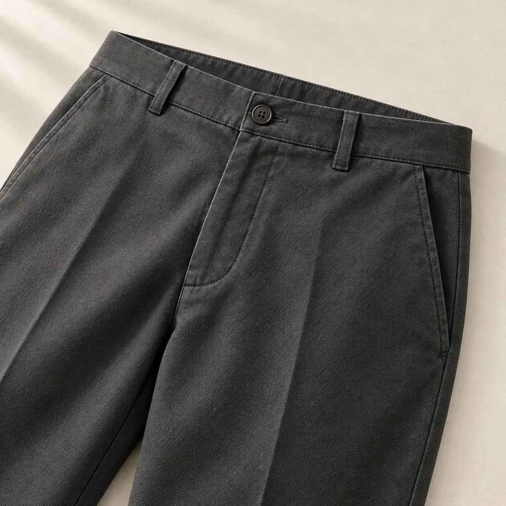 Waistband, button and pocket details of the charcoal trousers
