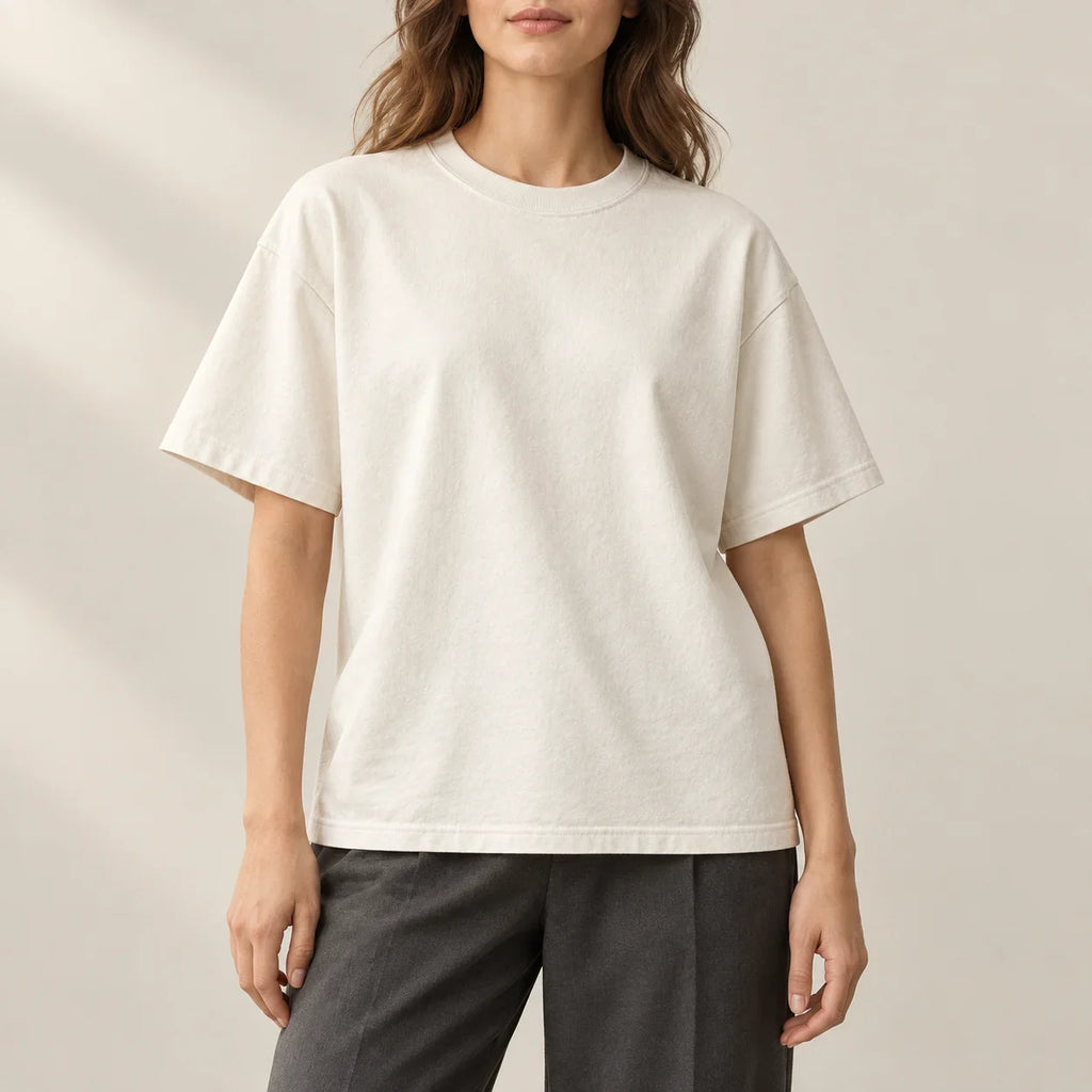 Relaxed ivory T-shirt worn with charcoal trousers